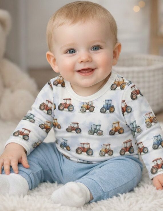 Kleiner Baby Junge trägt einen Traktor Langarm Body mit blauer Hose