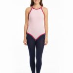 Erwachsene Frau trägt einen rosa Spaghettiträger-Body und eine schwarze Strumpfhose.
