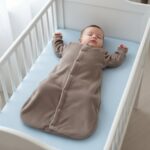 Baby-Junge schläft im drappfarbenen Wellsoft-Schlafsack im Kinderbett